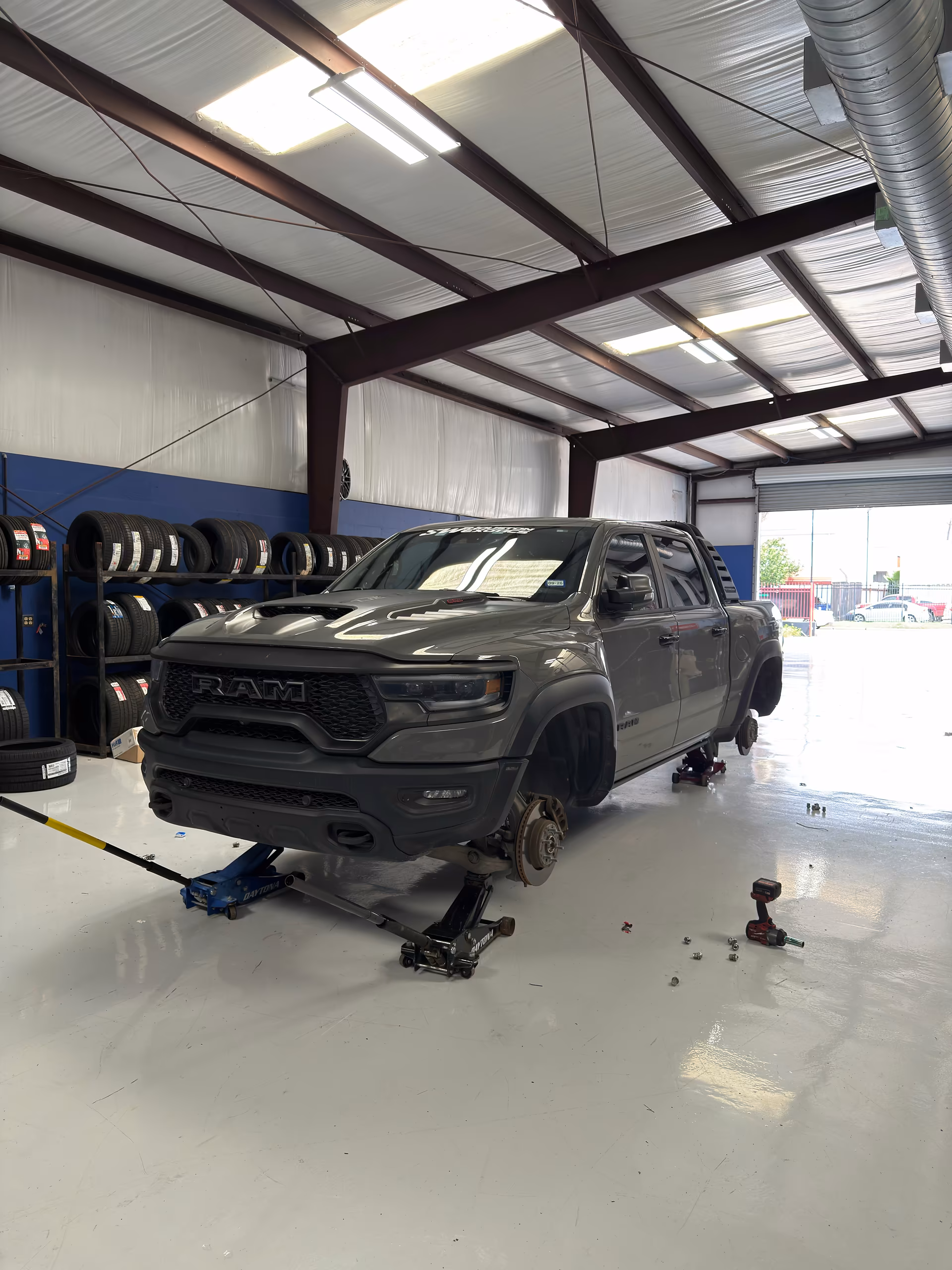 RAM truck raised in the Habibi service bay during wheel installation